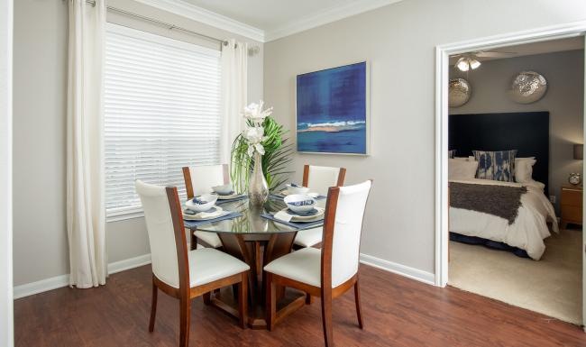 a dining room table with a vase of flowers on it